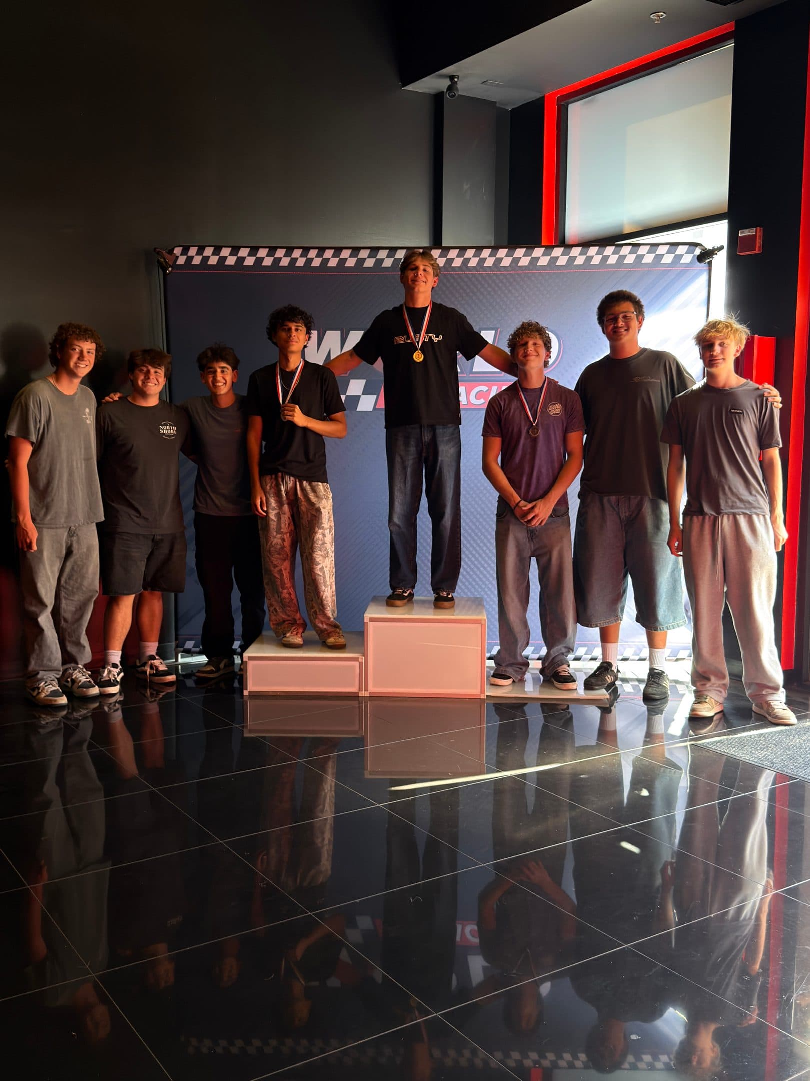A birthday group with medals on the World of Racing podium