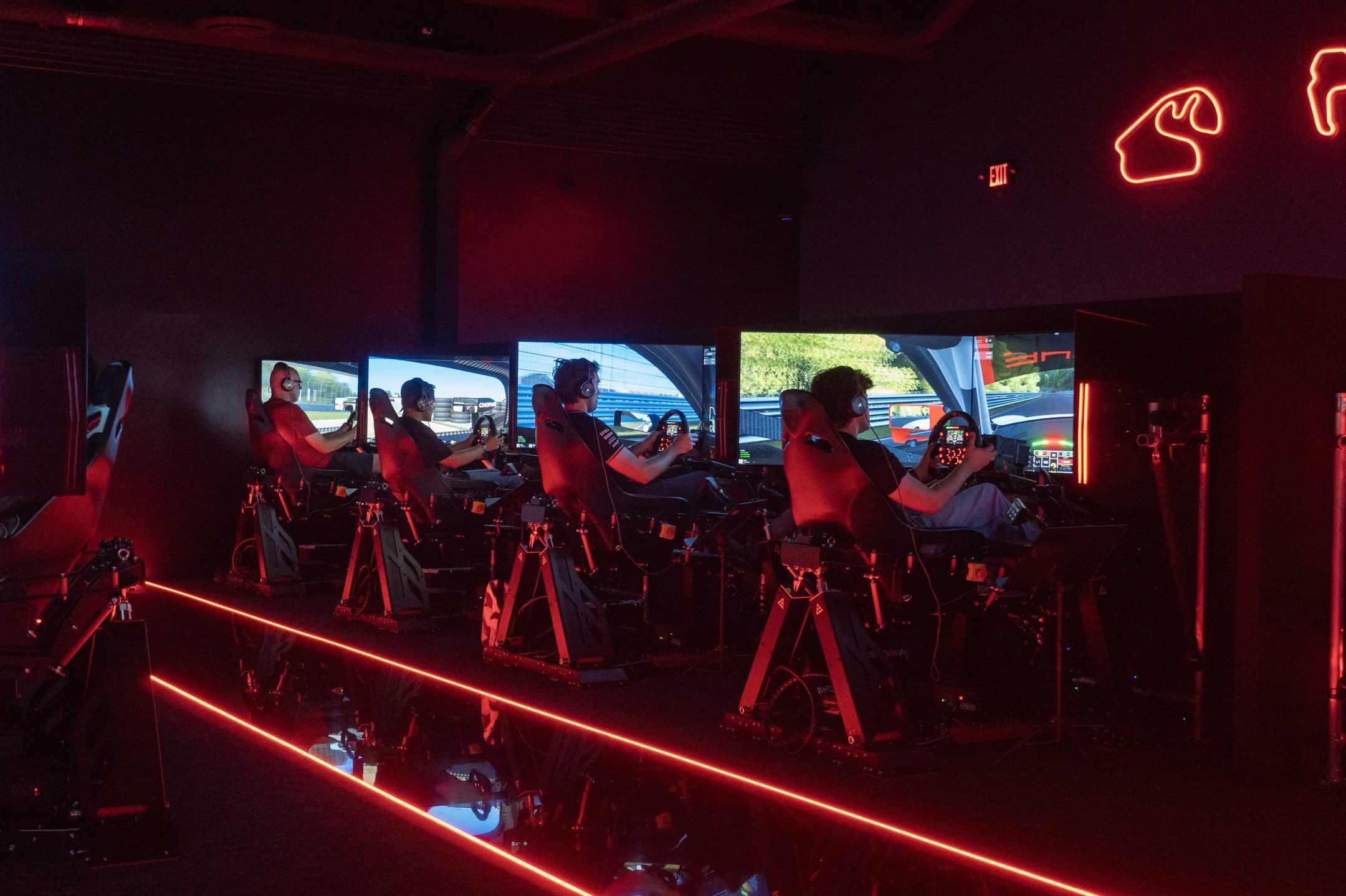 A row of racers on the sims under red neon