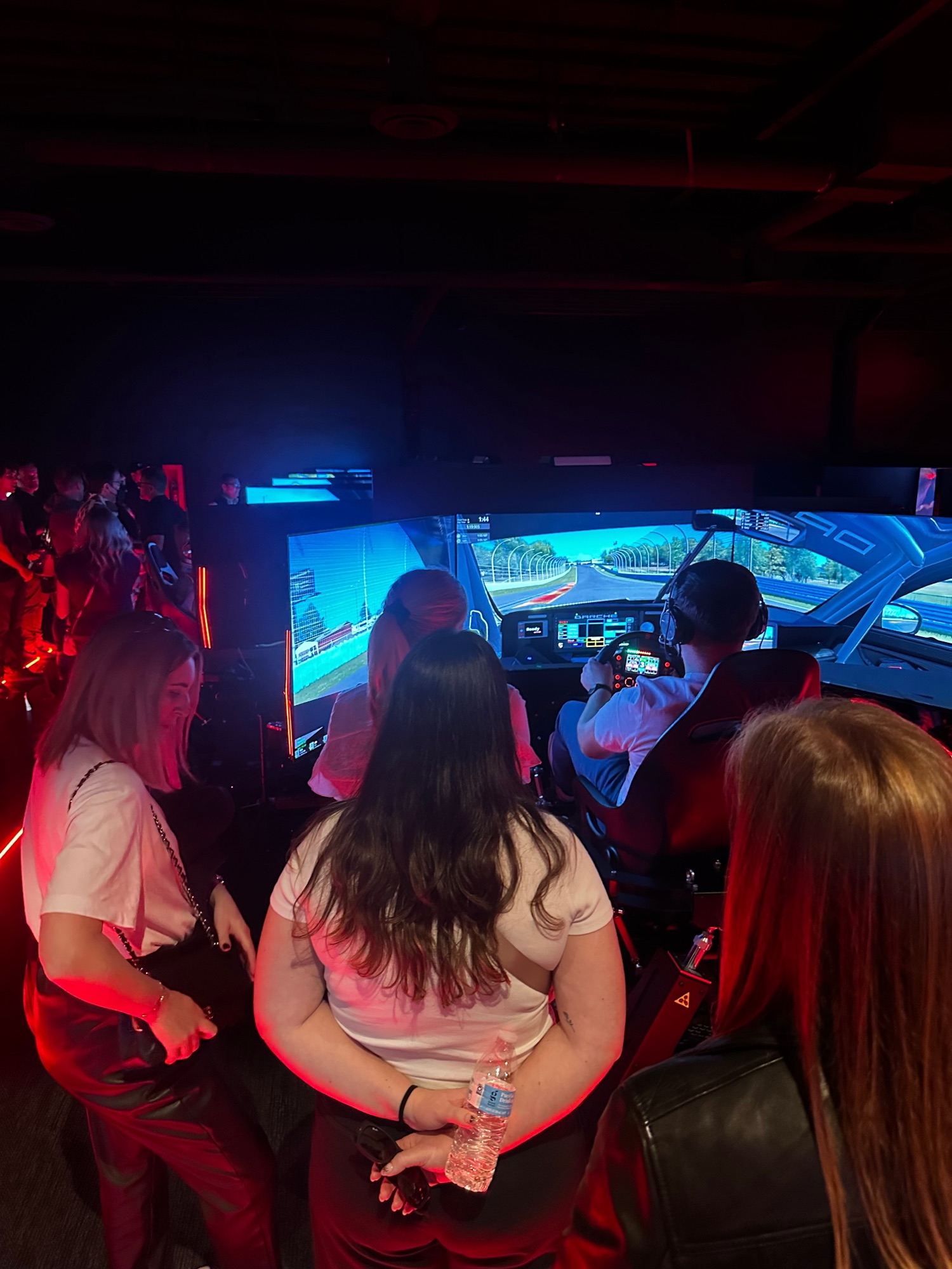 Friends watching a driver with headphones on, mid-session