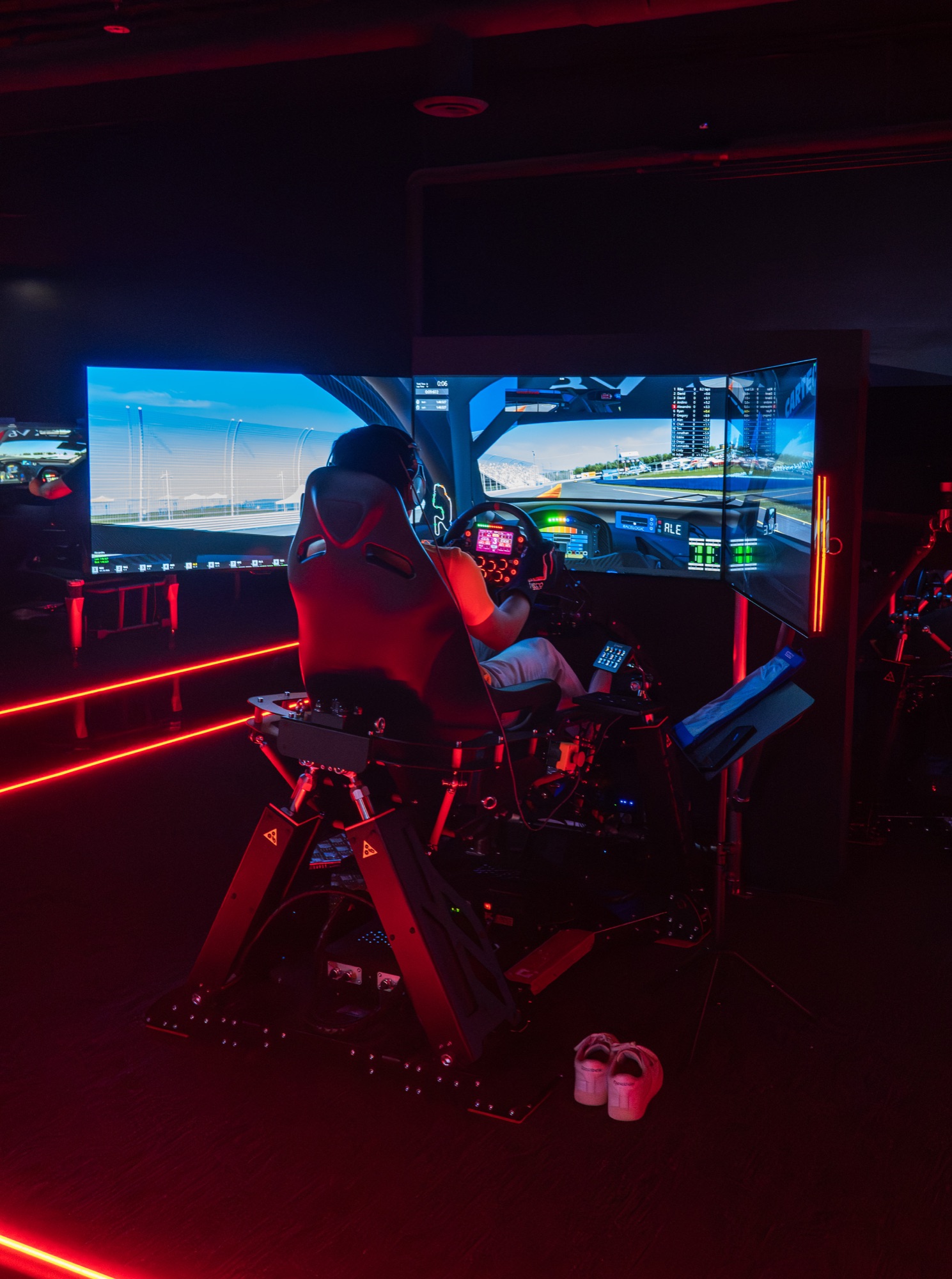 Full-motion LMP-style simulator with a triple-screen wraparound display at World of Racing Pasadena